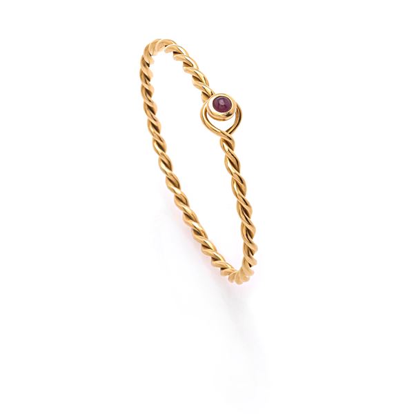 Gold bangle bracelet with cabochon cut ruby