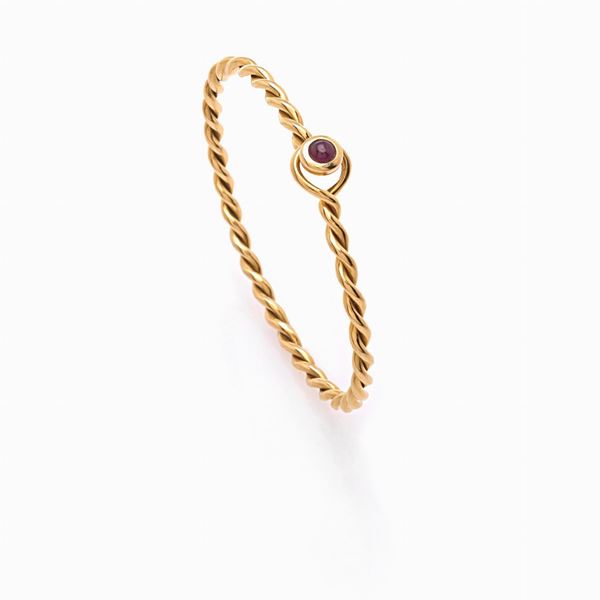 Gold bangle bracelet with cabochon cut ruby