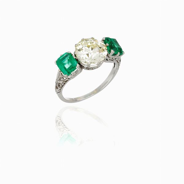 Platinum ring mounting diamond and emeralds