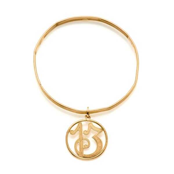 Yellow gold bangle with charm