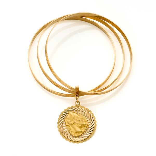 Three yellow gold bangles joined by charm 