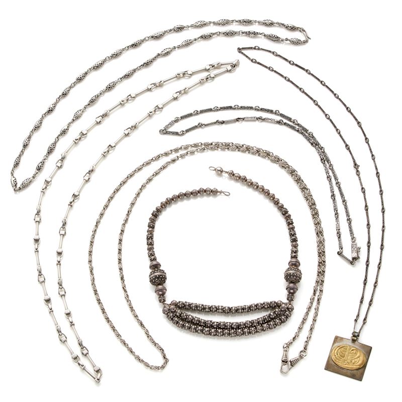 Cinque collane in argento, con pendente a placchetta in oro 18 Kt a soggetto sacro